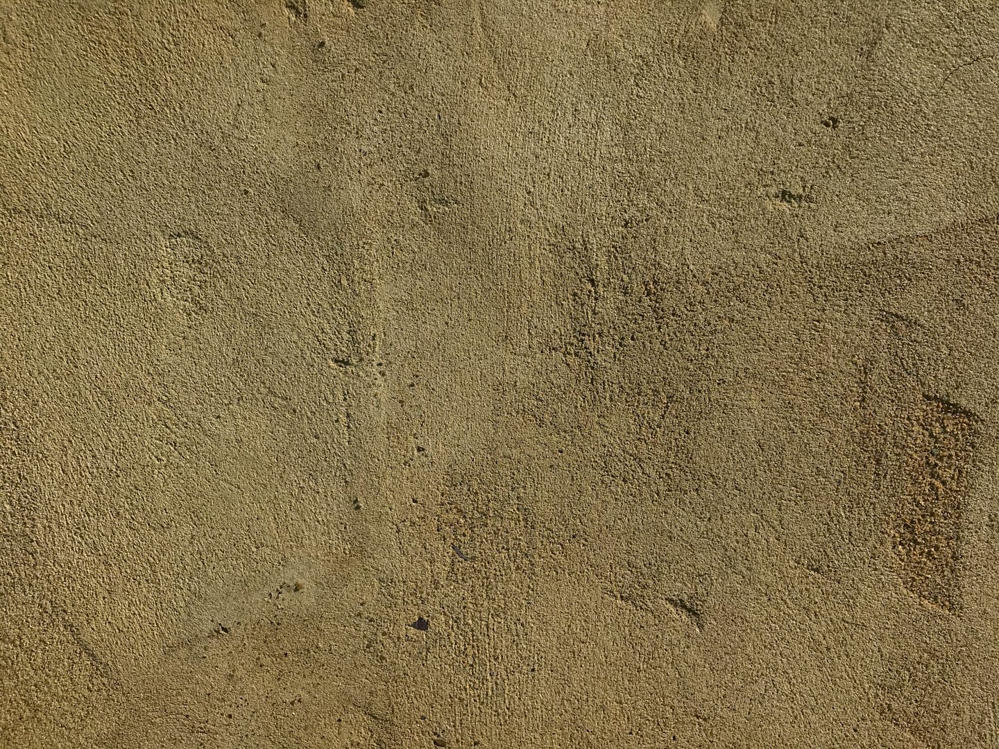 Texture granuleuse d'un mur extérieur en crépi.